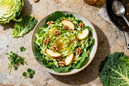 Salade vibrante de choudou avec noix, pommes et vinaigrette miel-noix dans une cuisine rustique